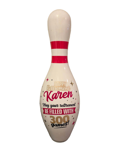 A custom bowling pin 'Happy Retirement Karen' with the text 'May your retirement BE FILLED WITH 300 games!' in red, black, and gold lettering.